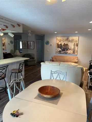 a kitchen with stainless steel appliances granite countertop a table chairs sink and cabinets