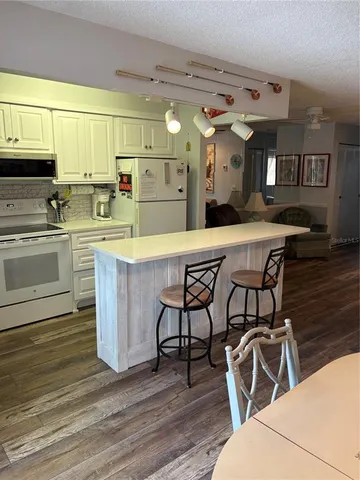 a kitchen with stainless steel appliances a white table chairs and a window
