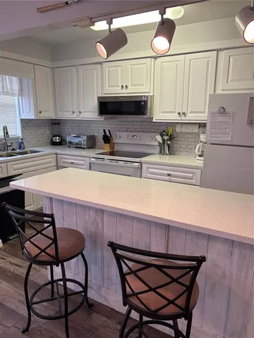 a kitchen with stainless steel appliances a stove a sink and cabinets