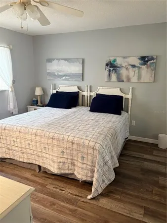 a bedroom with a bed and a flat tv screen on dresser