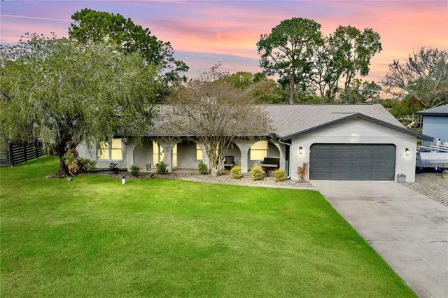 a front view of a house with a garden and trees