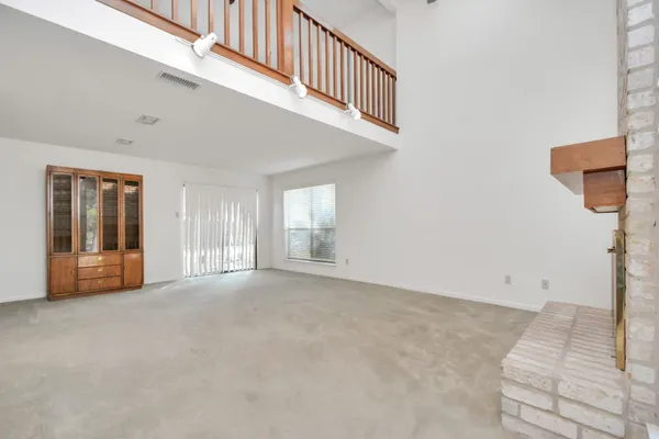 a view of an empty room with window and stairs
