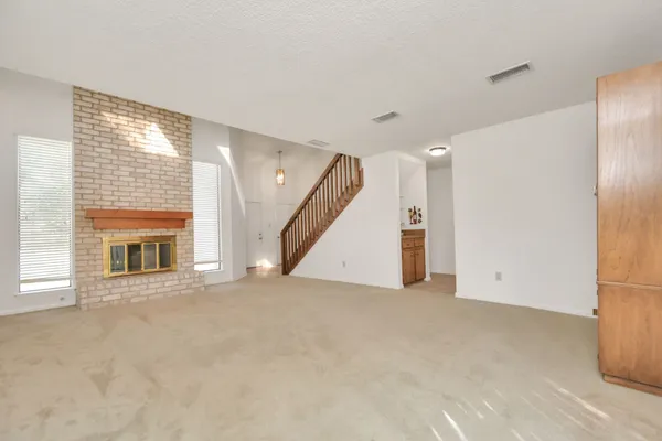 an empty room with a fireplace and entryway