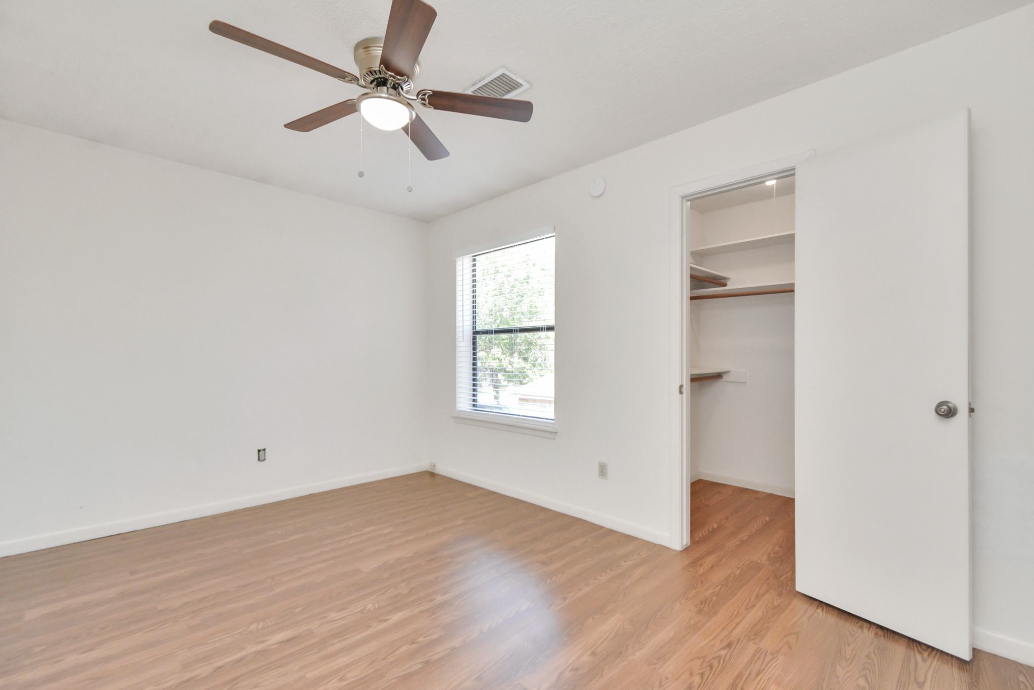 4743 Sabrina Drive Houston, TX 77066 - Photo 16 of 22 an empty room with wooden floor ceiling fan and windows