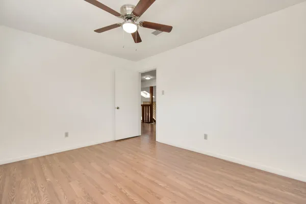 an empty room with closet and a ceiling fan