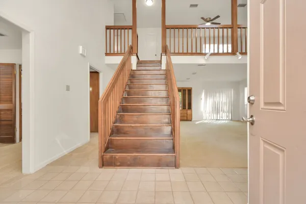 a view of staircase with white walls and a window