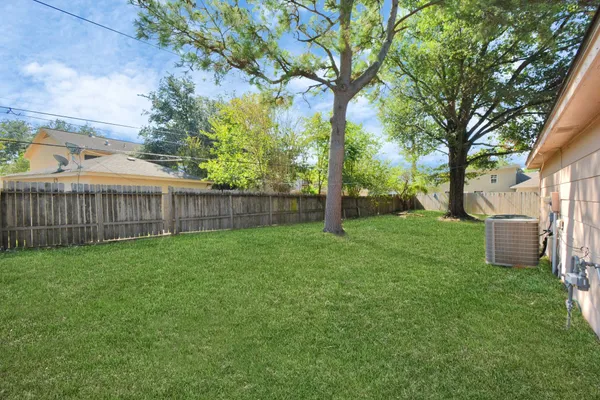 a view of a yard with a house and a large tree