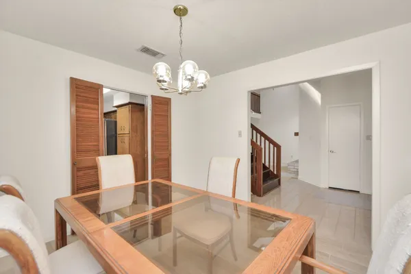 a view of a dining room and a livingroom with furniture wooden floor a chandelier