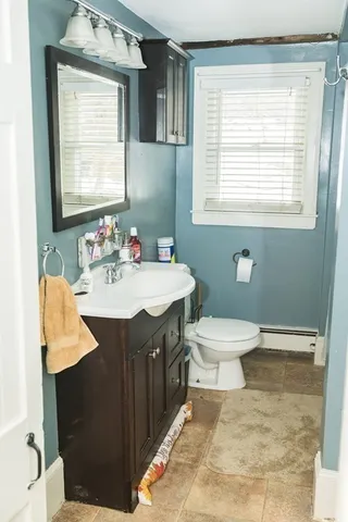 a bathroom with a sink toilet and a window
