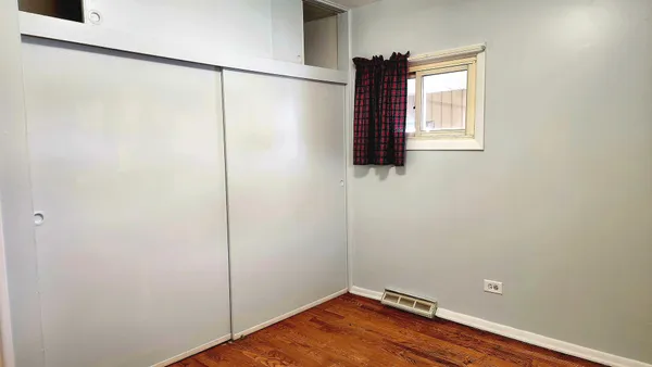 an empty room with windows and closet