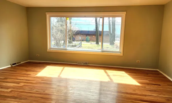 a view of a room with wooden floor and a window