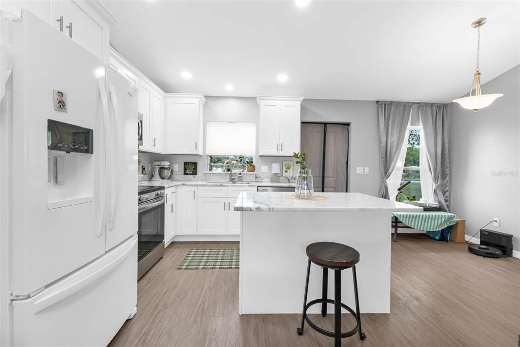 11615 Southwest Orange Avenue Arcadia, FL 34269 - Photo 6 of 27 a kitchen with kitchen island white cabinets and stainless steel appliances