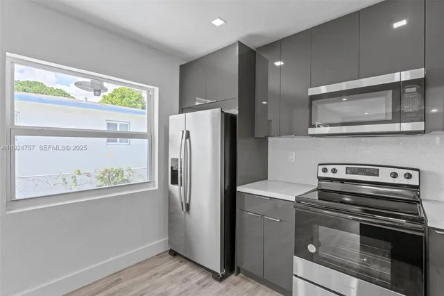 a kitchen with appliances a refrigerator and a window
