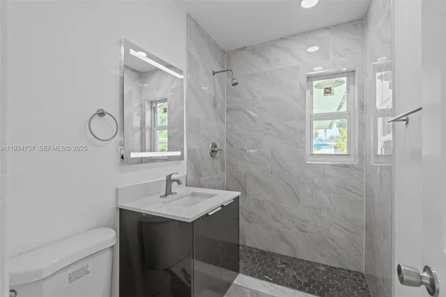 a bathroom with a sink toilet a mirror and shower