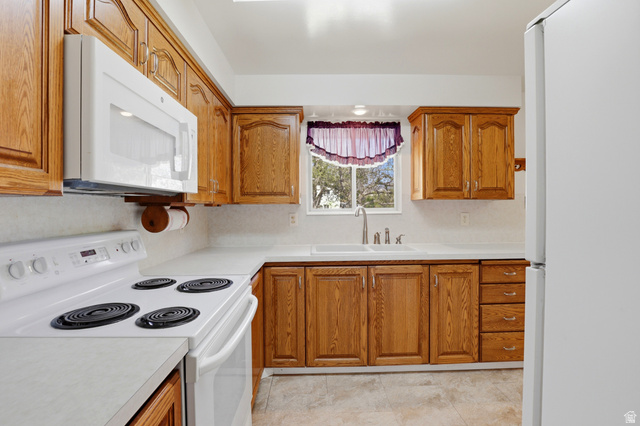 2348 North 770 West Clinton, UT 84015 - Photo 5 of 25 Kitchen featuring wood cabinetry, white countertops, built-in microwave, electric range, and a window above the sink