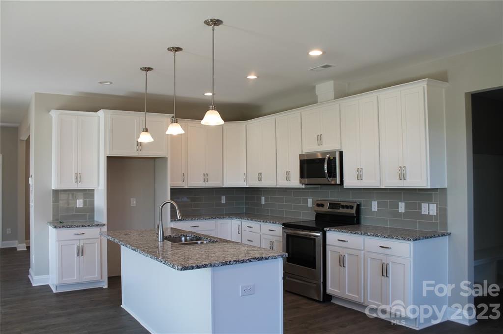 3220 Austin Chaney Road Monroe, NC 28110 - Photo 5 of 18 a kitchen with stainless steel appliances granite countertop a sink a stove a refrigerator and white cabinets