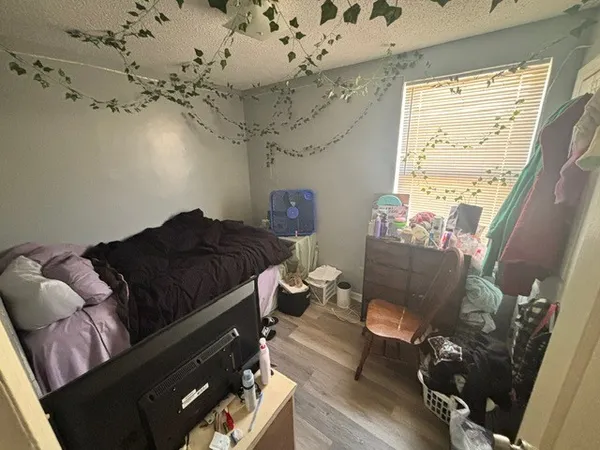 a bedroom with a bed dresser and a window