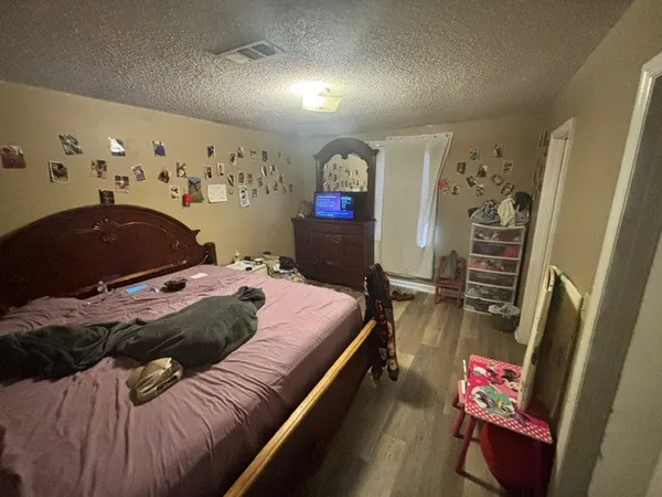 a bedroom with bed and a painting on the wall