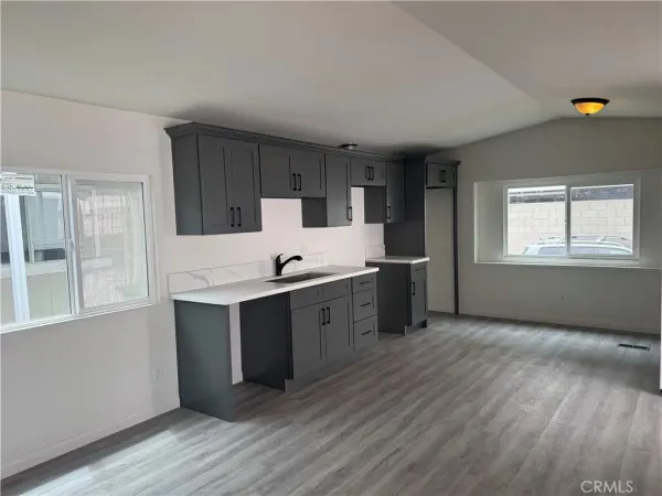 a kitchen with stainless steel appliances granite countertop a sink cabinets and wooden floor