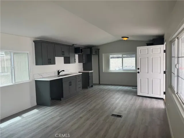 a view of a kitchen with wooden floor and electronic appliances
