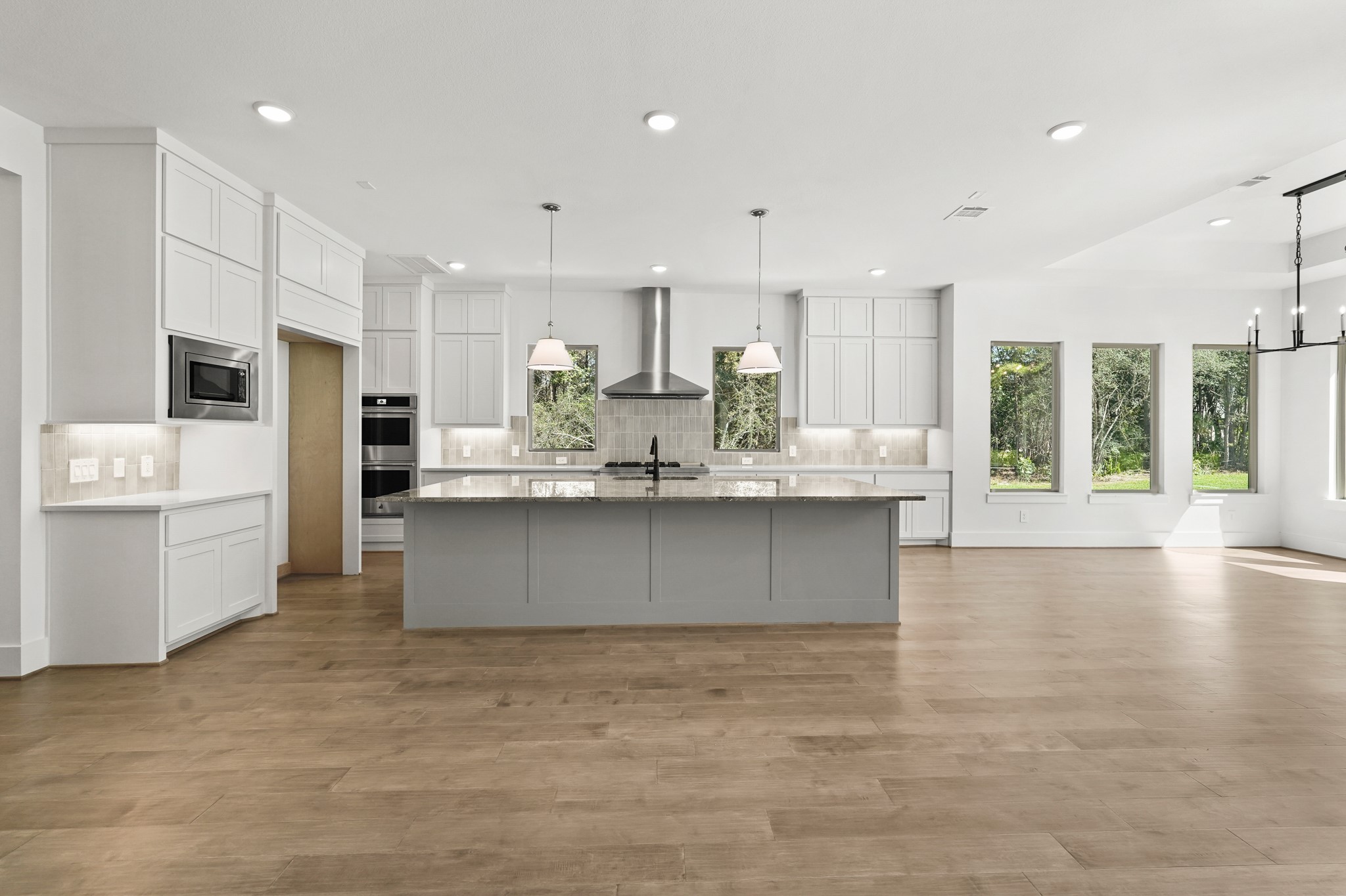 24919 Balmorhea Way Montgomery, TX 77316 - Photo 19 of 36 a large kitchen with stainless steel appliances kitchen island granite countertop a large counter top a stove a refrigerator white cabinets and a floors