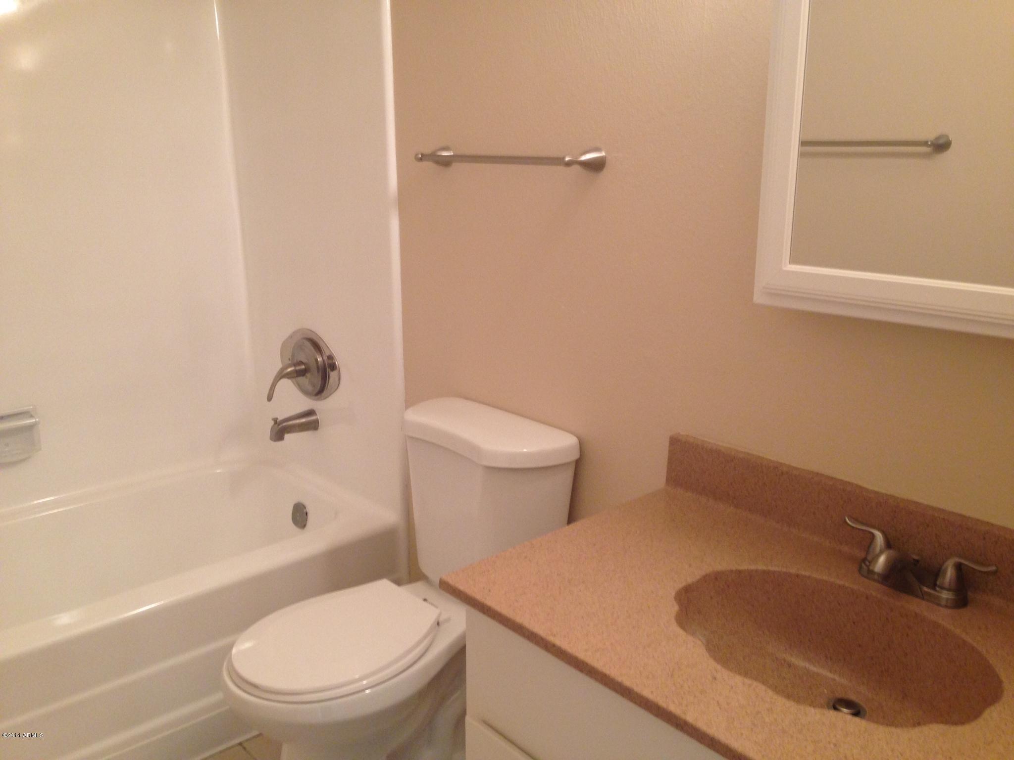 6829 East Osborn Road, Unit B Scottsdale, AZ 85251 - Photo 17 of 20 a white toilet sitting next to a bath tub