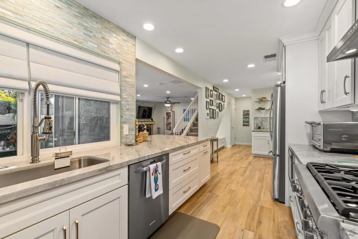 a large kitchen with stainless steel appliances and a large window