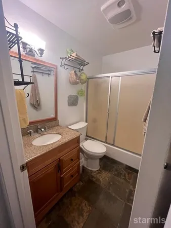 a bathroom with a sink a toilet a mirror and shower