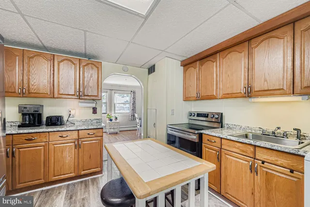 a kitchen with granite countertop wooden cabinets and white appliances