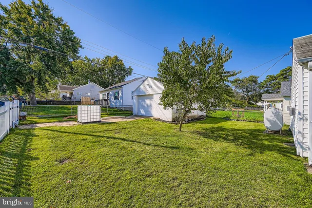 a view of a house with a big yard potted plants and large tree