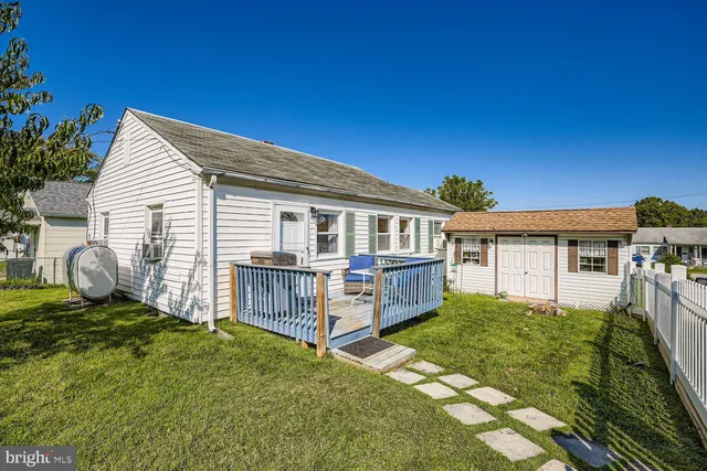 a view of a house with a small yard and wooden fence