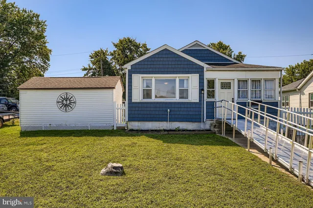 a view of a house with wooden fence and a yard