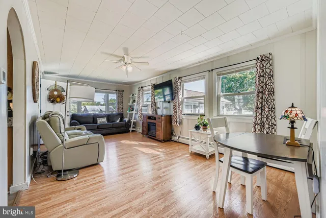 a living room with furniture a large window and wooden floor