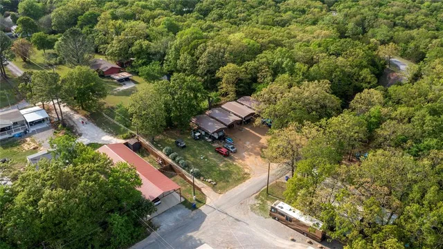 an aerial view of residential house with outdoor space and trees all around