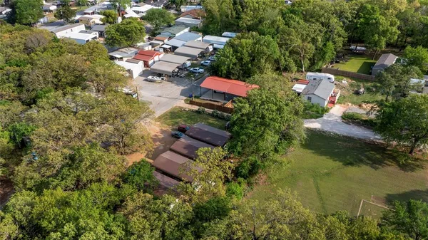 an aerial view of residential house with outdoor space and trees all around