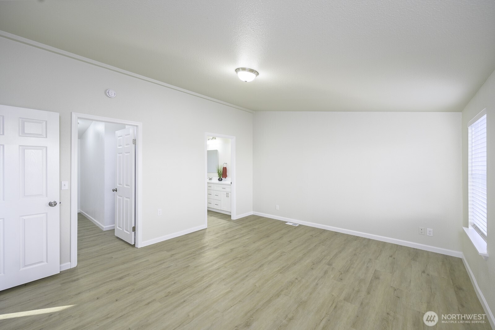 4948 Northeast E 7 Road Moses Lake, WA 98837 - Photo 8 of 22 an empty room with wooden floor and white walls