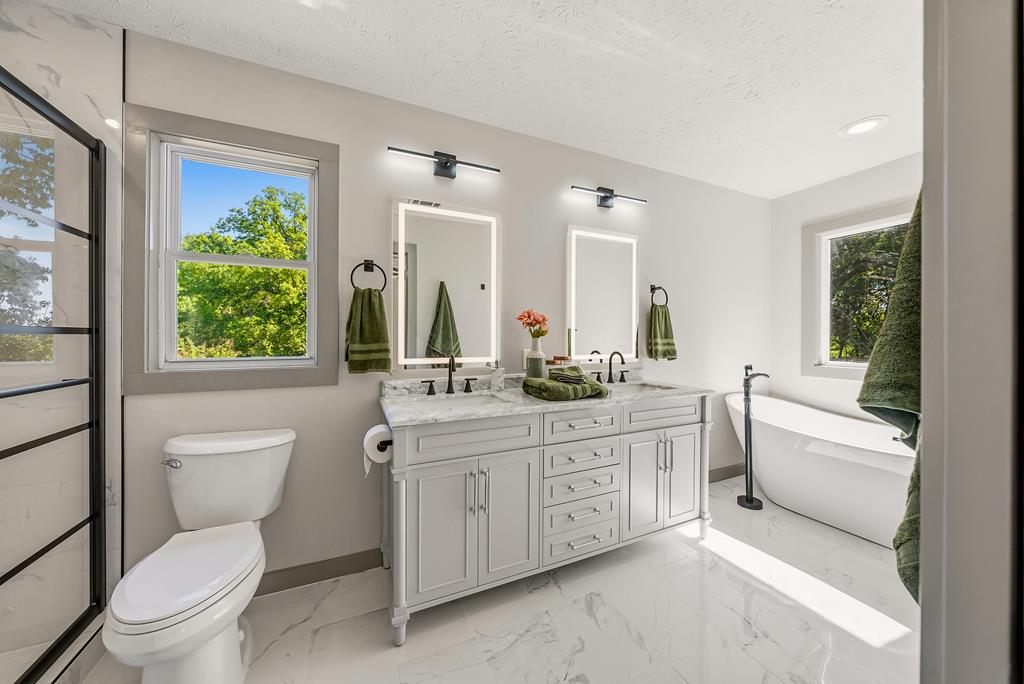 7313 Sesame Street Columbus, GA 31909 - Photo 13 of 43 a spacious bathroom with a granite countertop toilet a sink and a large mirror
