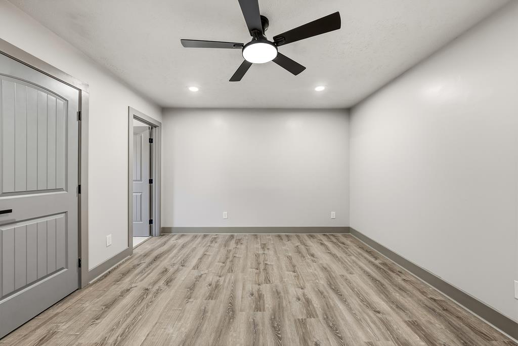 7313 Sesame Street Columbus, GA 31909 - Photo 21 of 43 an empty room with wooden floor ceiling fan and windows