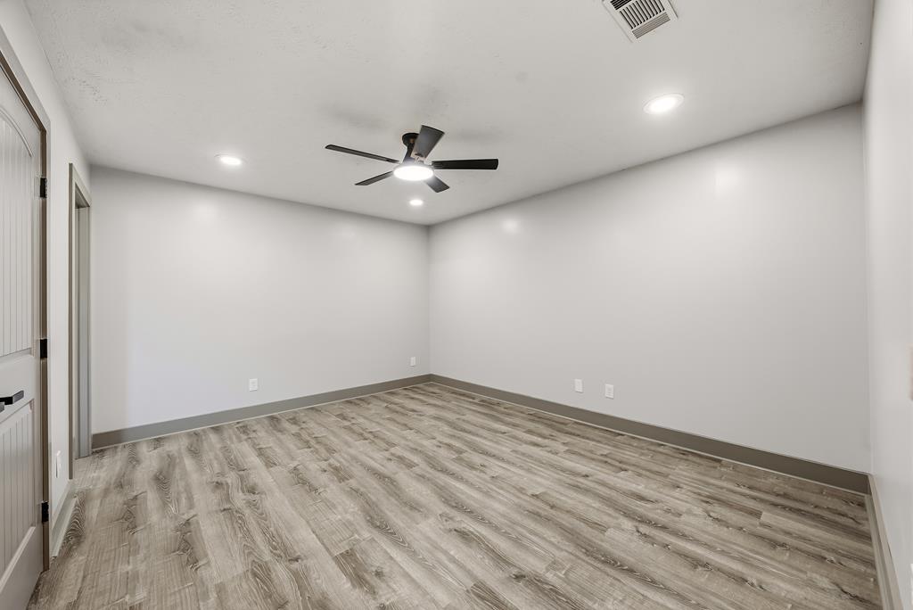 7313 Sesame Street Columbus, GA 31909 - Photo 22 of 43 an empty room with a ceiling fan and wooden floor