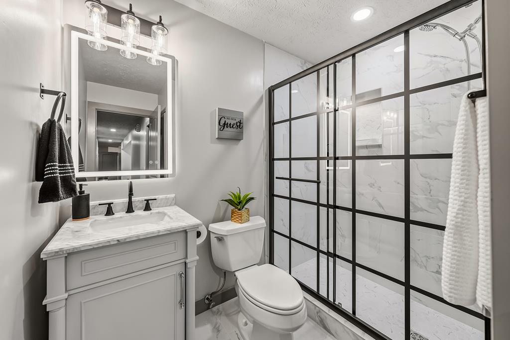 7313 Sesame Street Columbus, GA 31909 - Photo 25 of 43 a bathroom with a granite countertop toilet sink and mirror