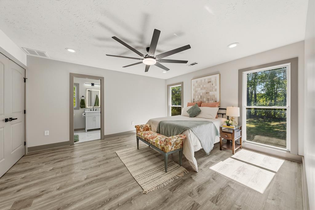 7313 Sesame Street Columbus, GA 31909 - Photo 10 of 43 a spacious bedroom with a bed a window and a chandelier