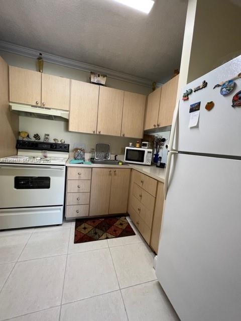 13783 Southwest 66th Street, Unit 215A Miami, FL 33183 - Photo 6 of 13 a kitchen with a cabinets a sink and white appliances