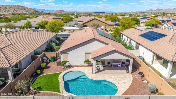 an aerial view of a house with swimming pool and mountains