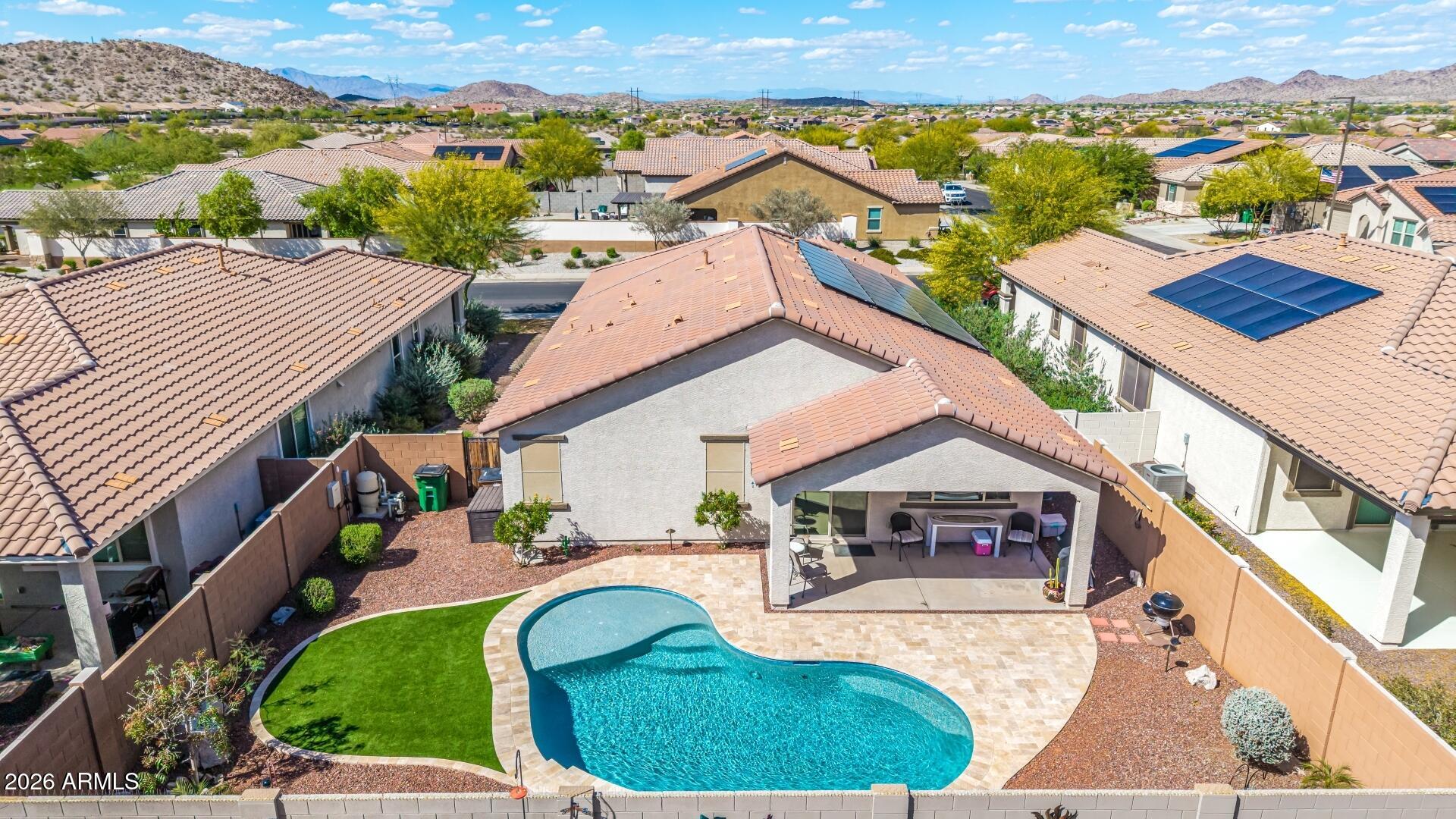 18021 West Indigo Brush Road Goodyear, AZ 85338 - Photo 1 of 47 an aerial view of a house with swimming pool and mountains