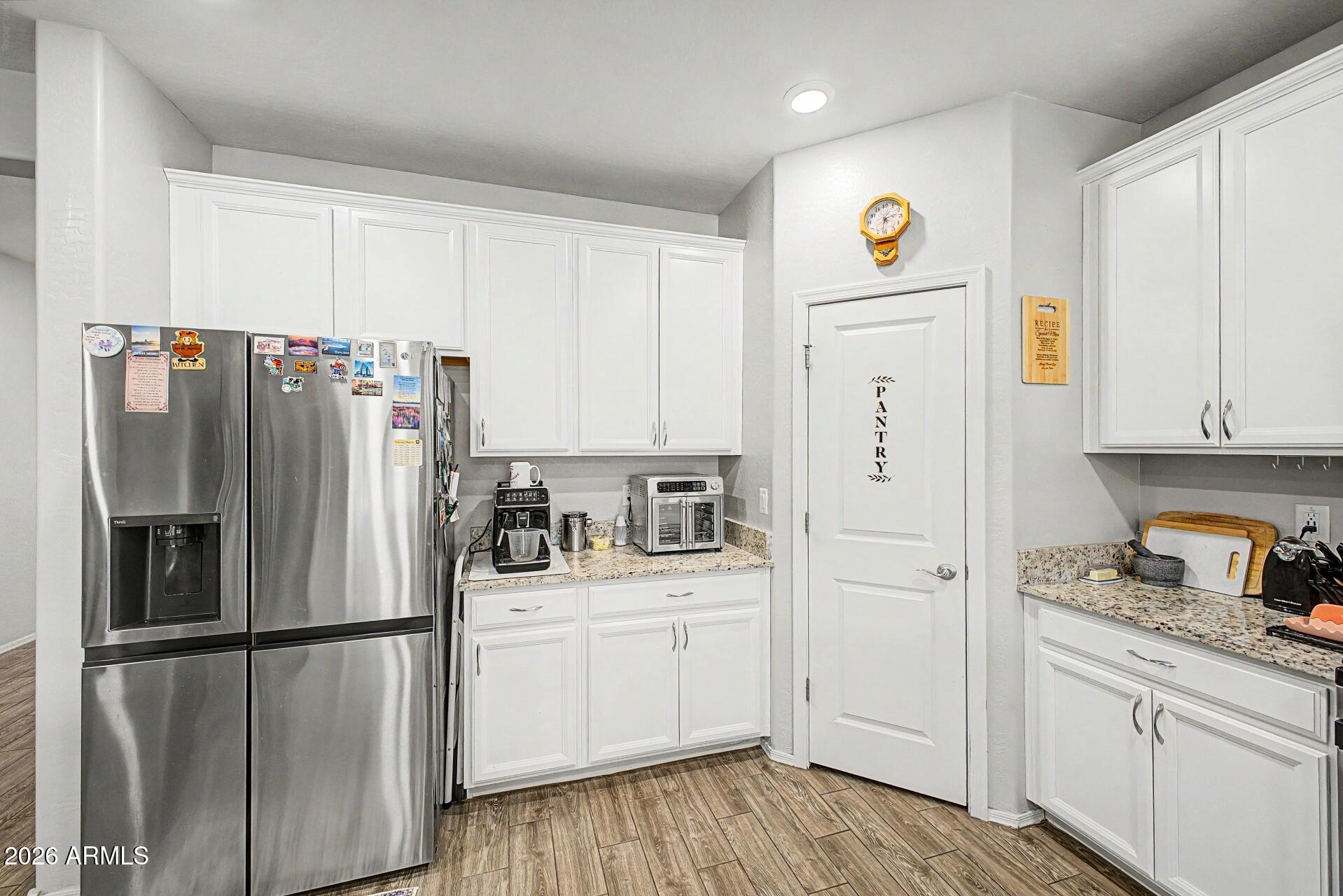 18021 West Indigo Brush Road Goodyear, AZ 85338 - Photo 11 of 47 a kitchen with stainless steel appliances a refrigerator sink and cabinets