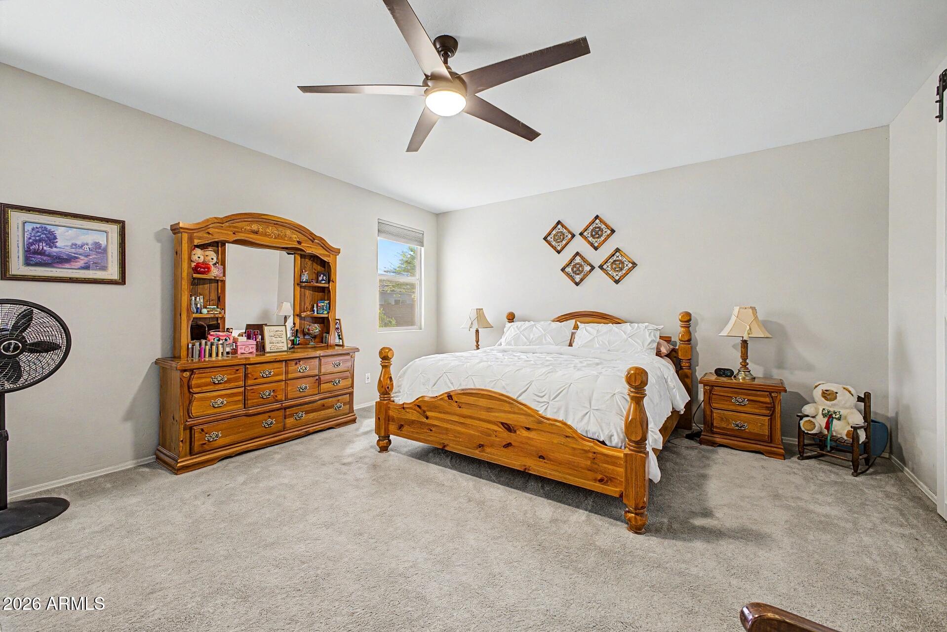 18021 West Indigo Brush Road Goodyear, AZ 85338 - Photo 12 of 47 a bed room with a bed and a dresser