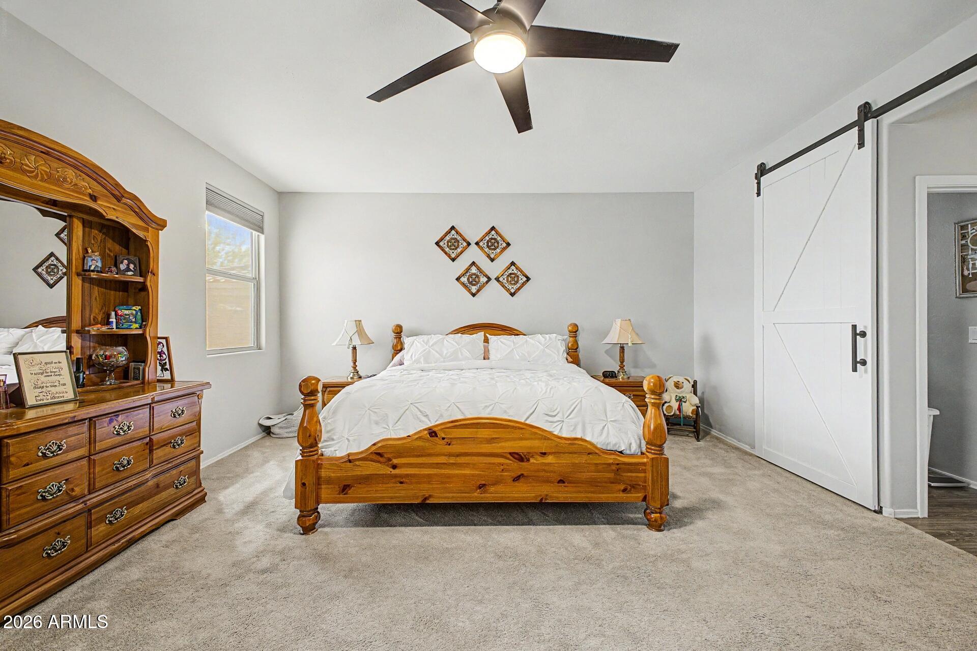 18021 West Indigo Brush Road Goodyear, AZ 85338 - Photo 13 of 47 a bedroom with a bed and wooden floor
