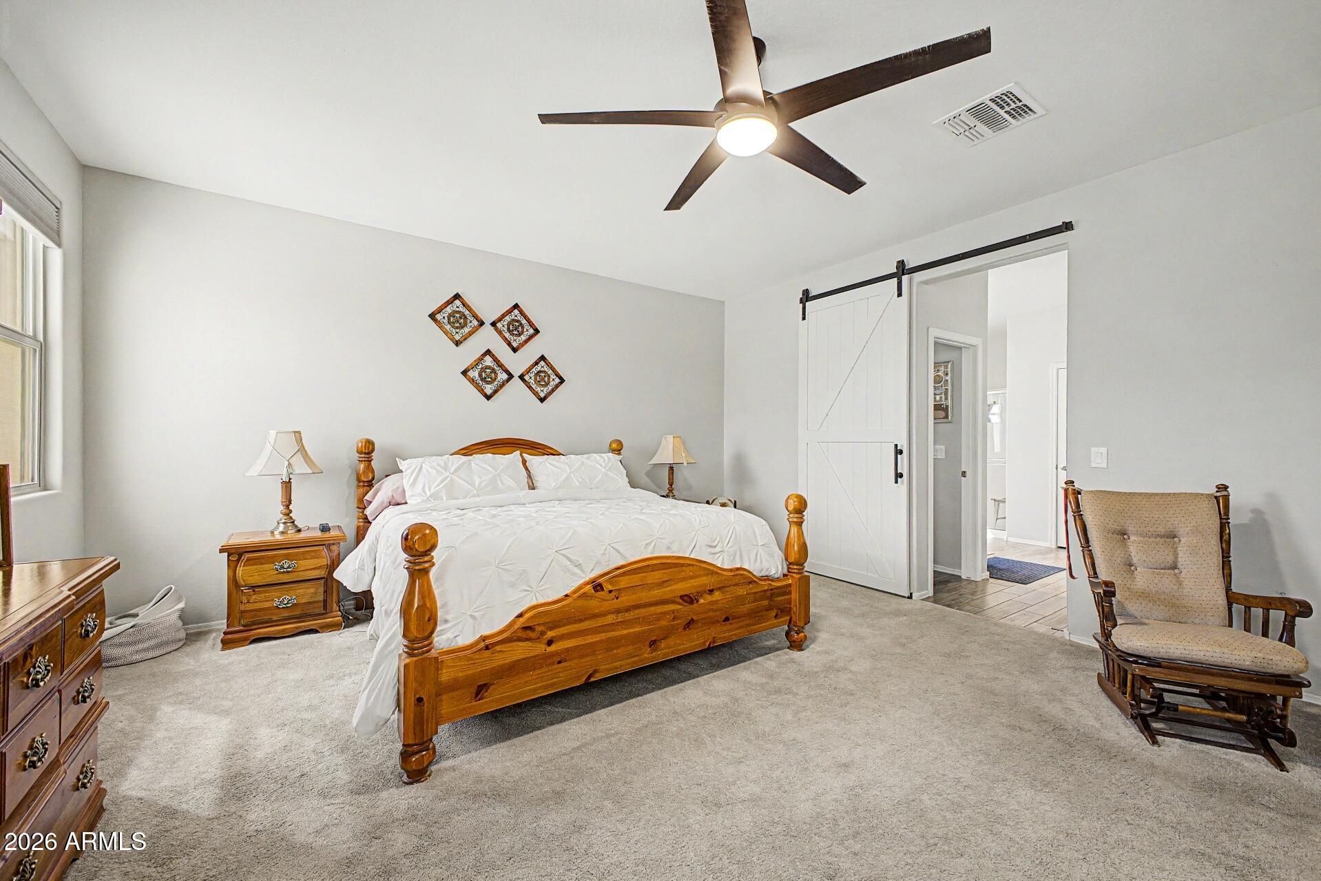 18021 West Indigo Brush Road Goodyear, AZ 85338 - Photo 14 of 47 a bedroom with a bed and a chair