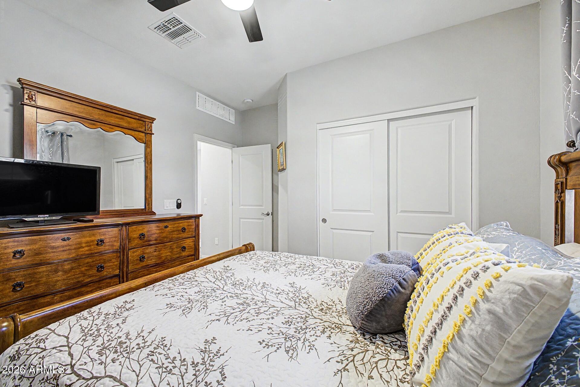 18021 West Indigo Brush Road Goodyear, AZ 85338 - Photo 19 of 47 a bedroom with a bed and flat screen tv