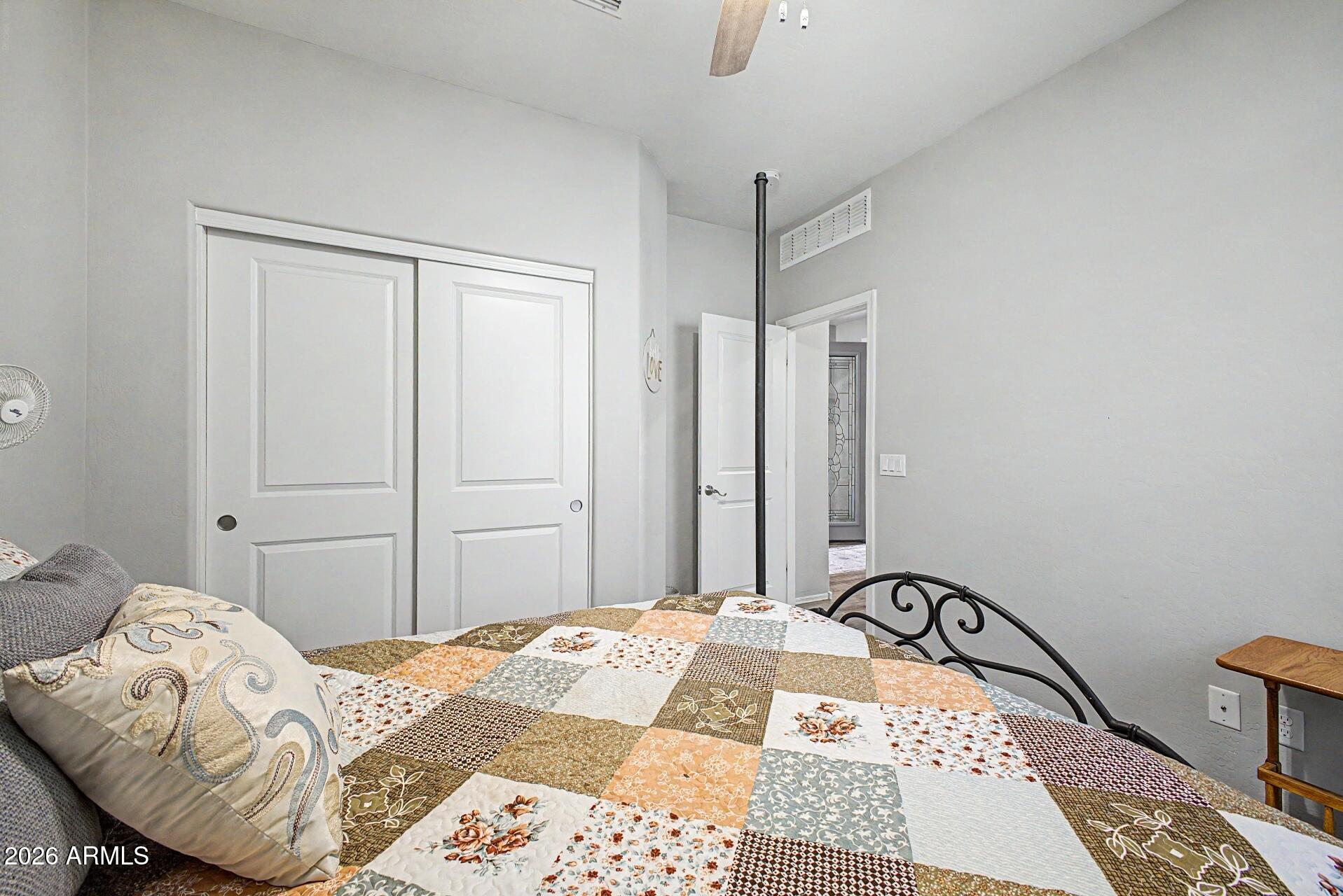 18021 West Indigo Brush Road Goodyear, AZ 85338 - Photo 21 of 47 a bedroom with a bed and wooden floor